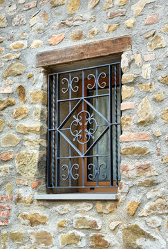 window with iron grating on stone wall