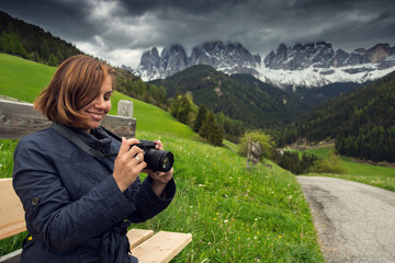 Woman with digital camera taking landscape photo