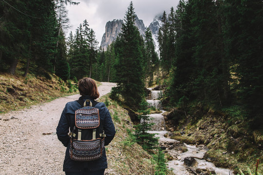 Woman traveler with backpack going to mountains