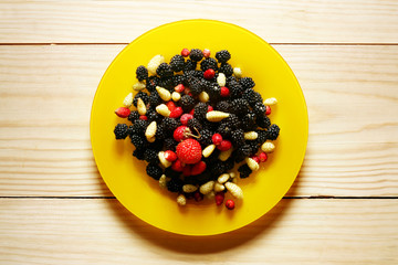 Blueberry in yellow plate on wood background