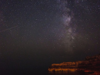 Milky way and shooting star over the cliff, long exposure image