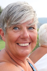 A portrait of a mature english lady smiling and with natural grey hair, 2017