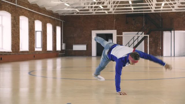 Male breakdancer dancing in sport gym. Super slow motion