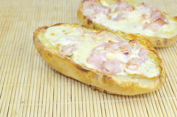 High Angle view of a Baked potato stuffed with ham and cheese on a wood surface