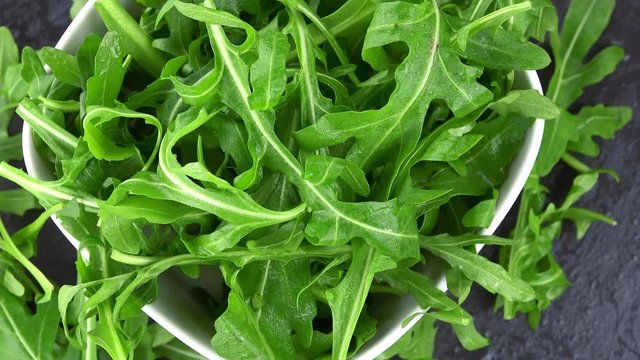 Portion of Arugula Salad rotating on a wooden plate (not loopale; 4K)