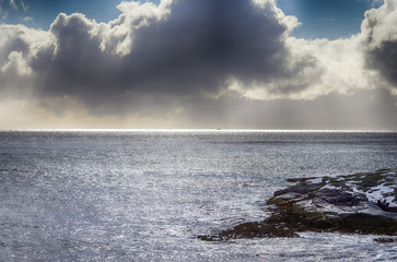 Amazing Slim Line of Sunlight of Sun Going Down On Horizon Over the Ocean at Lofoten Islands in Norway. Against Grey Cloudy Skies.