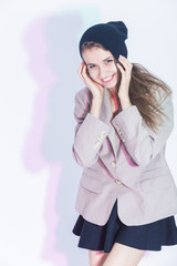 Youth Fashion and Lifestyle Concepts. Portrait of Happy Smiling Caucasian Brunette Girl in Trendy Jacket And Posing in Sexy Skirt Against White.