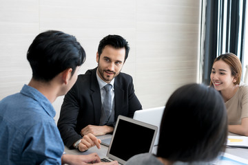Group of multi-ethnic business partners discussing ideas in meeting room at office. Business people meeting corporate communication teamwork concept.