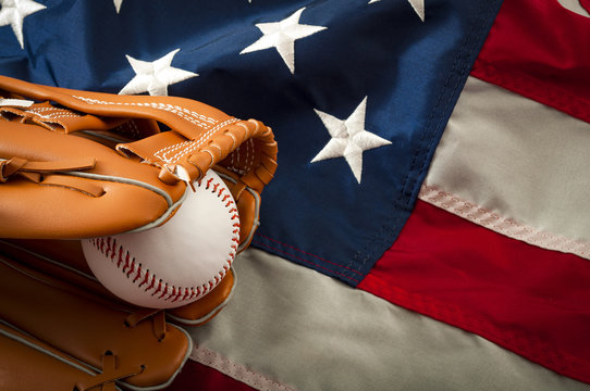 American sports and college athletics concept with the USA flag in the background and macro on a vintage baseball glove holding a ball with copy space
