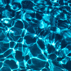 Water in swimming pool with sun reflection. Blue water. Water abstract background