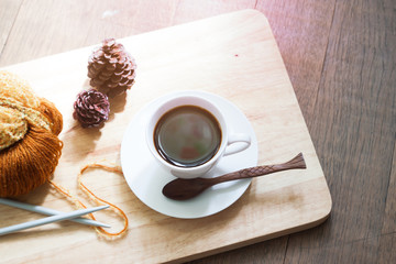 A cup of hot coffee with a yarn knitting, Autumn season color