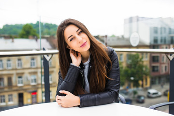 beautiful young woman sitting alone in cafe on a terrace wait for order. Coffee break after shopping. beautiful young woman having coffee in cafe