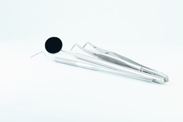 Photo dental instruments mirror, probe, tweezers, mask, binocular glasses magnifier, model of human jaw placed on white background