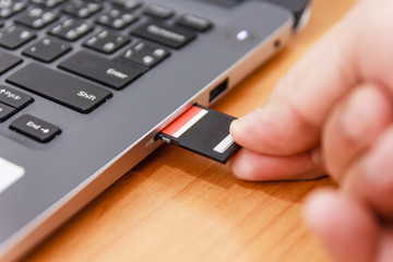Plugging in SD Card into personal computer ready for photo file transfer, Selective focus