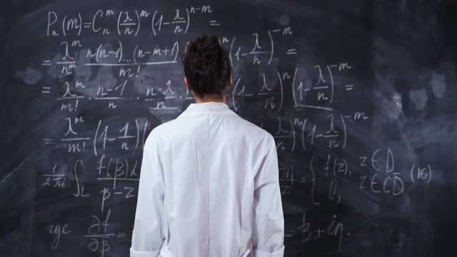 Pretty handsome attractive woman student or teacher in white robe trying to solve and prove the mathematic theorem. No face. Slider glidetrack camera movement. Back spine middle shot in 4k Ultra HD.