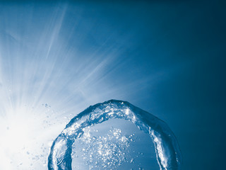 Bubble ring underwater ascends towards the sun.