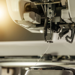 Picture of Embroidery machines part of embroiding space close up needle and pesser foot image color warm tone