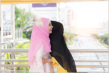 Two Muslim woman friend celebrating hug together