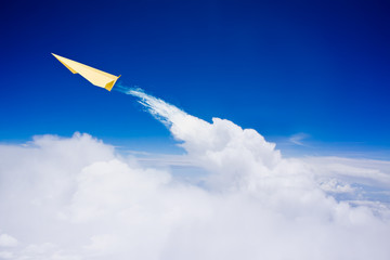 Naklejka na ściany i meble Yellow paper plane flying against blue sky