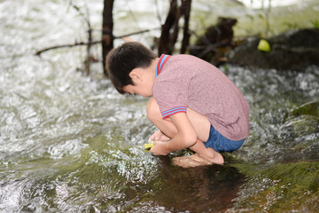Littl boy playing at waterfall with happy and smile outdoor activeites with family