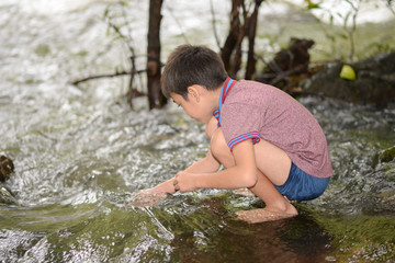 Littl boy playing at waterfall with happy and smile outdoor activeites with family