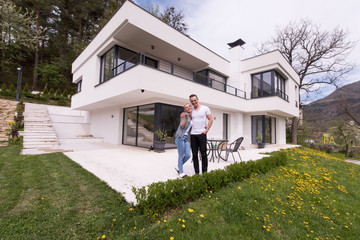 Fototapeta premium couple hugging in front of new luxury home