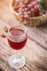 Glass of wine or grape juice and fruit on wooden table