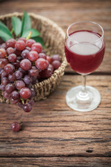 Glass of wine or grape juice and fruit on wooden table