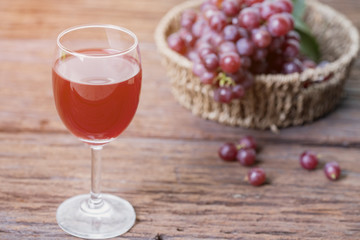 Glass of wine or grape juice and fruit on wooden table