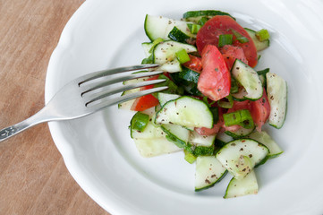 Salad of red tomatoes and cucumbers on a white plate