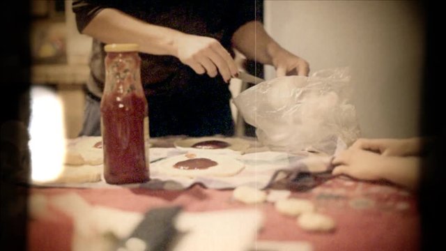 Fake 8mm amateur film: a little girl and her mother cooking panzerotti. Tomato juice, dough, fresh mozzarella.
