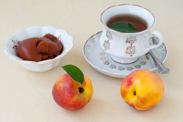Still life: tea, jam and nectarine on the table