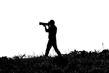 Black and white photo, silhouette of photographer in nature