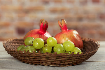 Pomegranates and grapes in a wicker bowl