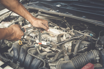 Hands of mechanic working in auto repair shop with process  vintage style