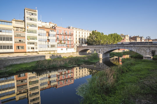 Girona river houses landmark, reflecting water in this famous city close to Barcelona on a blue summer sunny sky