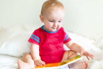 Cute cauasian reading a book on his own before naptime.