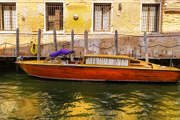 Vintage wooden water taxi or cabin cruiser docked in venice Italy.
