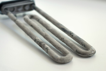 Washing machine heater with scum on a white background