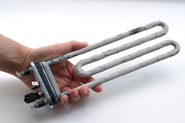Hand holding washing machine heater with scum on a white background