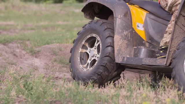 Close-up of riding wheel of quad bike HD slow-motion video. All-terrain vehicle ATV. Four-wheeler quadricycle transport and extreme sport.