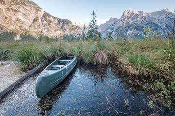 Fototapeta premium Altes Kanu bei Sonnenuntergang am Almsee in Grünau, Salzkammergut, Österreich