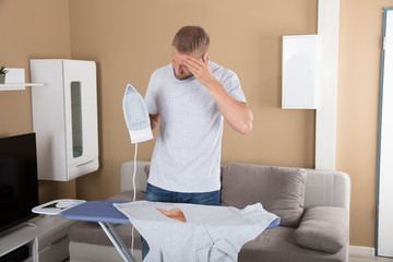 Sad Man Standing Near Iron Board Holding Iron