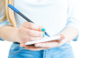 Close-up of woman writing in notepad