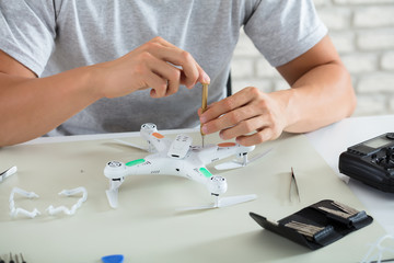 Obraz na płótnie Canvas Man Repairing Quadrocopter Drone