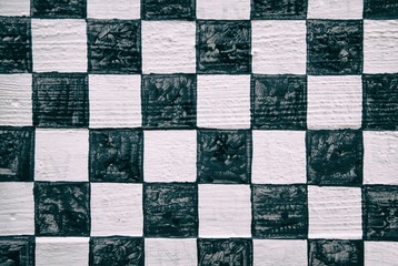 Black and white checkerboard pattern on wood panel background