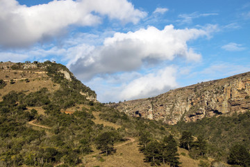 Dry Grassland Gorge Mountains and Valleys Against  Cloudy Sky