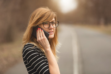 Attractive cute girl talking on her cellphone outdoors.