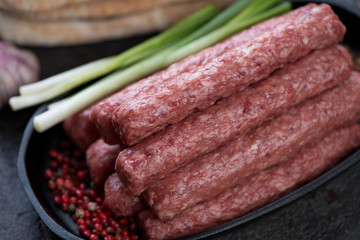 Close-up of fresh uncooked cevapcici or skinless beef sausages, traditional dish in the Balkans