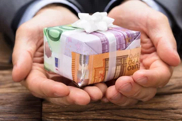 Fotobehang Businessman Holding Gift Box Made From Euro Papernotes © Andrey Popov